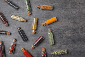 Naklejka premium Glass bottles with different spices on gray background