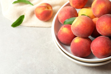 Plates with fresh sweet peaches on table