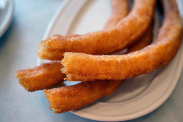 Plate of fried churro pastries with sugar