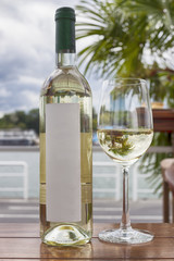 Bottle of white wine and glass by the sea