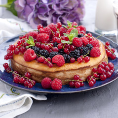 Homemade pastries with fruits and flowers hydrangea. The cake is decorated with various fresh berries and mint. Summer food. Sweet breakfast. Copy space.