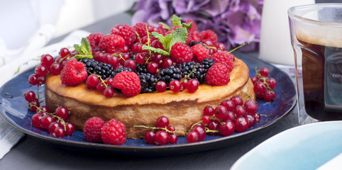 Homemade pastries with fruits and flowers hydrangea. The cake is decorated with various fresh berries and mint. Summer food. Sweet breakfast. Copy space,