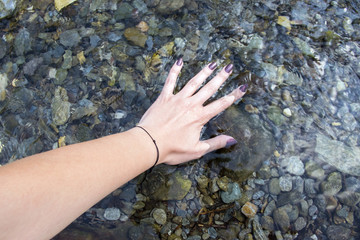 Hand in a cold water mountain river 