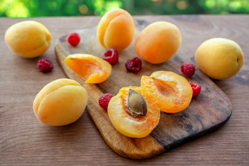 Fresh raspberry and Apricot on wooden cutting board. Fresh ripe fruits