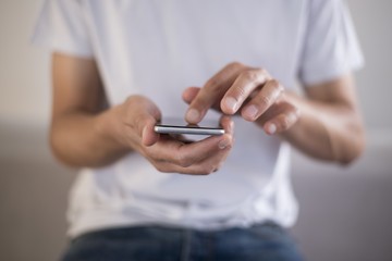 Young man using a touchscreen smartphone - Hands close-up - Using technology