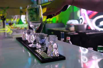 Woman's hand pours vodka into a glass