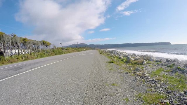 tourist man driving car on route no.6 bruce bay beach new zealand