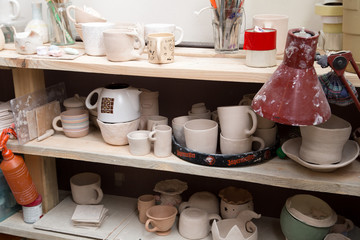Handmade ceramic potson a shelf. Pottery workshop concept.