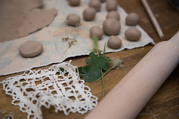 Close up of pottery tools like rolling pin, folliage and lace  for printing at a pottery workshop