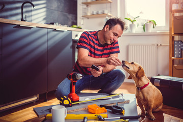 Men feeding his dog during kitchen renovation