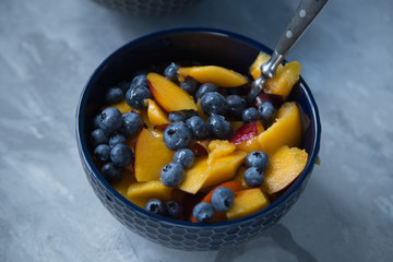 Breakfast bowl with oat flakes and fruits and berries like blueberries , nectarines and bananas