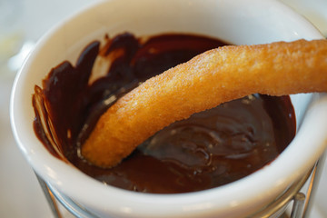 Fried churro pastry dipped in chocolate sauce