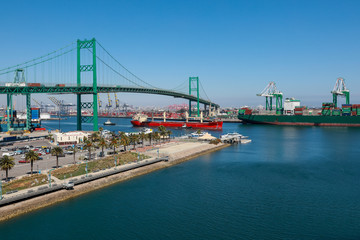 Vincent Thomas Bridge and Container Ships Unloading in Los Angeles California Shipping Port