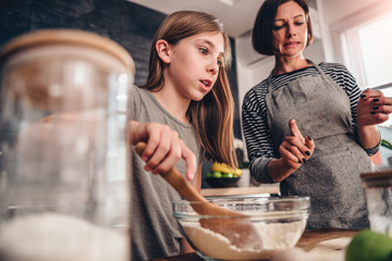 Mother and daughter put to much sugar in mixing bowl
