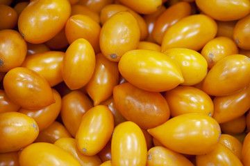 Heap of fresh ripe orange tomatoes without branches close up.