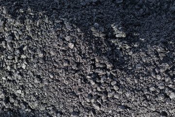 Texture of fresh hot asphalt. Black background resembling anthracite.