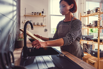 Woman cleaning cutting board - obrazy, fototapety, plakaty