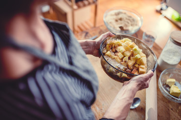 Woman making apple pie on wooden table