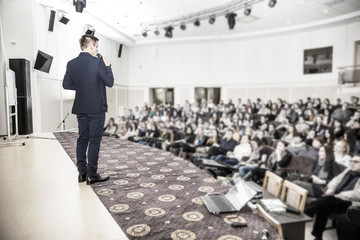 speaker speaks at a business conference in front of entrepreneurs and journalists