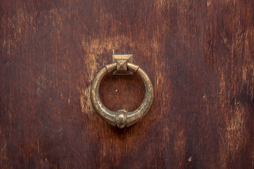 Golden door knocker on wooden door