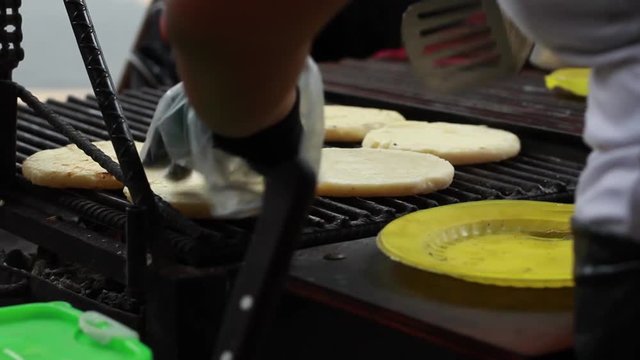 Close up of woman flipping arepas in Cali, Colombia