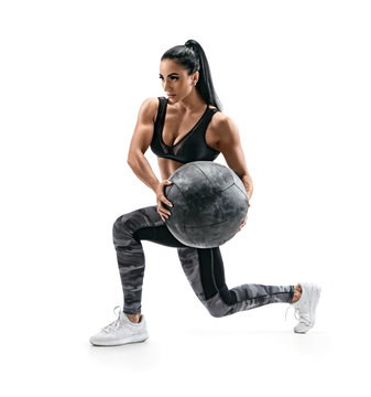 Muscular woman doing lunge twist exercise with med ball. Photo of woman with great physique isolated on white background. Strength and motivation