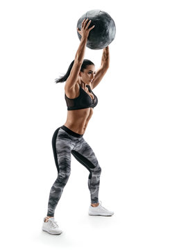 Strong woman doing exercise with med ball. Photo of latin woman in fashionable sportswear isolated on white background. Strength and motivation.
