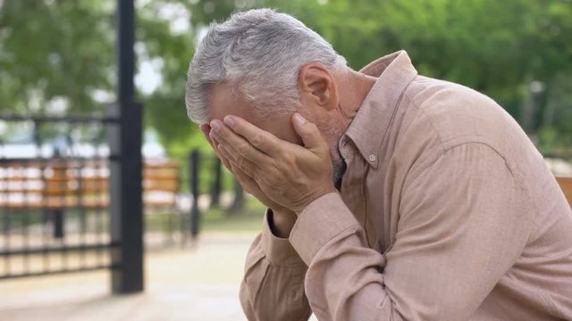 Sad Old Man Sitting On Hospital Garden Bench, Pensioner Crying In Sorrow