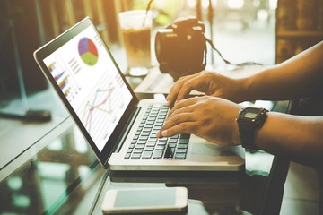 Business person analyzing financial statistics displayed on the laptop screen