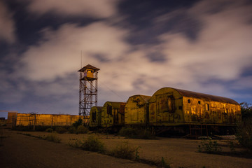 Fototapeta na wymiar Old army watchtower in abandoned military base at night 