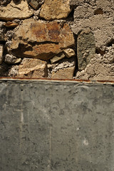 Old rock wall with some metal patches