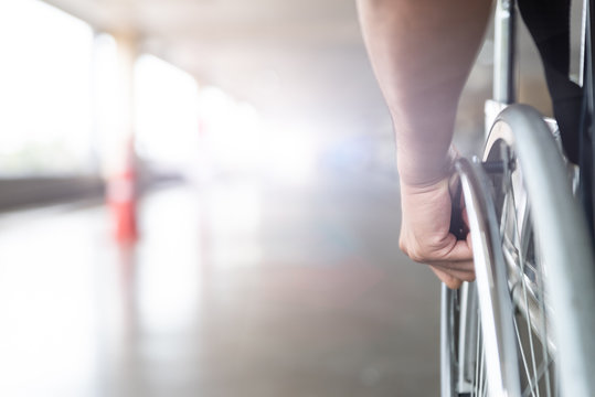 closeup disabled man hand on wheel of wheelchair