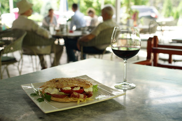 Pizza sandhwhich in an outside restaurant enviorment