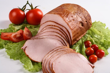 Slised ham with vegetables. Still life.