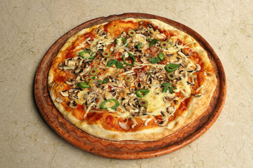 Vegetarian pizza with onions, peppers olives and cheese, top view on a restaurant table