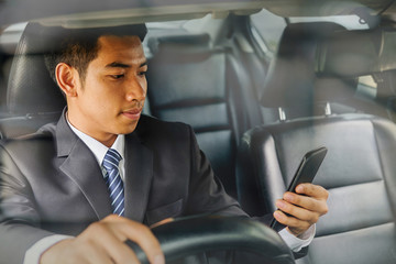 Successful businessman sitting behind the wheel of a car