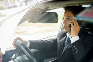 Successful businessman sitting behind the wheel of a car