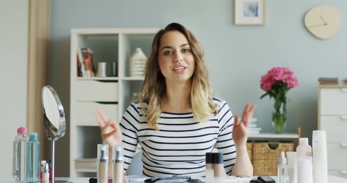 Video tutoring class on a beauty and makeup from pretty young happy woman sitting in the comfortable room. Indoor.