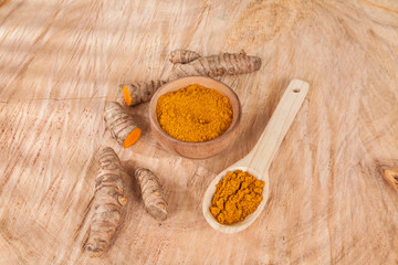 Fototapeta na wymiar Turmeric powder and fresh turmeric on wooden background