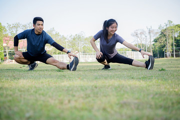 Happy couple stretching across the Stadium. Living healthy lifestyle.