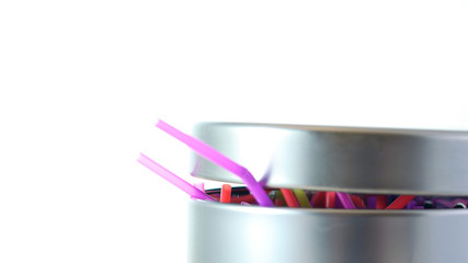 Banning plastic straws enviromental concerns concept, throwing straws into trash can close up.