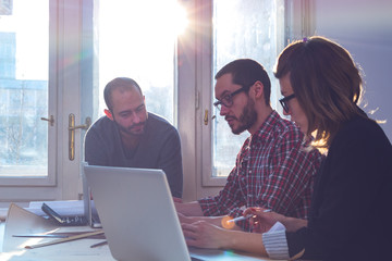 Group of young architects in a sunny office.