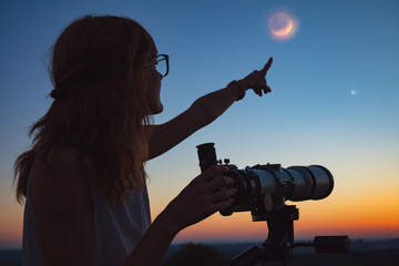 Girl looking at lunar eclipse through a telescope. My astronomy work. - obrazy, fototapety, plakaty