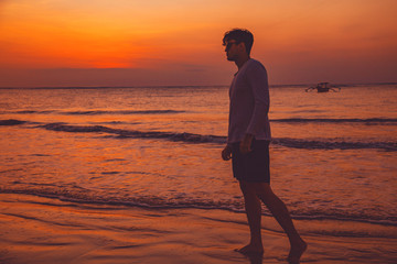 Fototapeta premium Man enjoying on the ocean beach in sunset / sunrise time.
