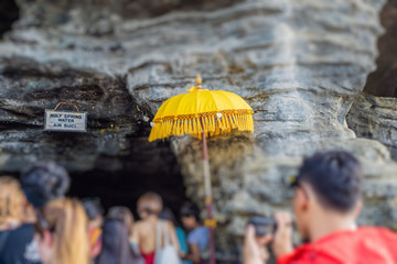 tilt shift photo traditions umbrella in temple of Bali against the rocks