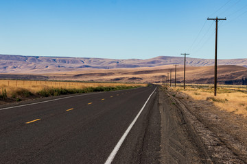 Palouse country highway going in to the distance in to rolling desert hills