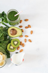 Glass of green vegetable smoothie on white background from top view