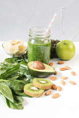 Glass of green vegetable smoothie on white background