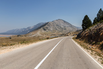 On the road through an arid landscape in Bosnia and Herzegovina on a sunny summer day near Mostar.