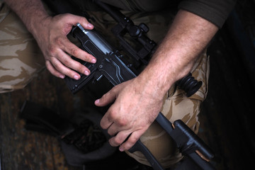 soldier hands and Sniper rifle close up. war.